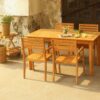Kansas Dining Set featuring a solid teak wood dining table and chairs, placed in a rustic outdoor patio with natural fine sanded finish.